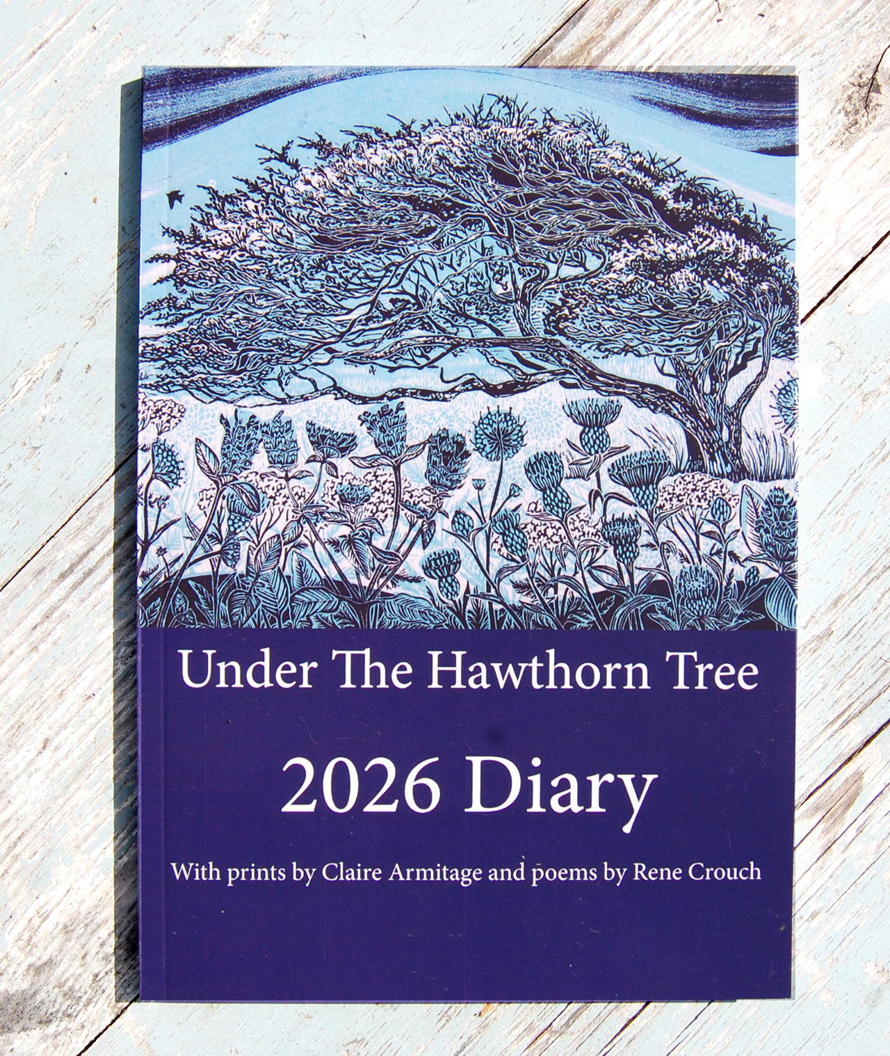 Diary titled 'Under The Hawthorn Tree 2026 Diary' with nature-themed cover on a wooden surface